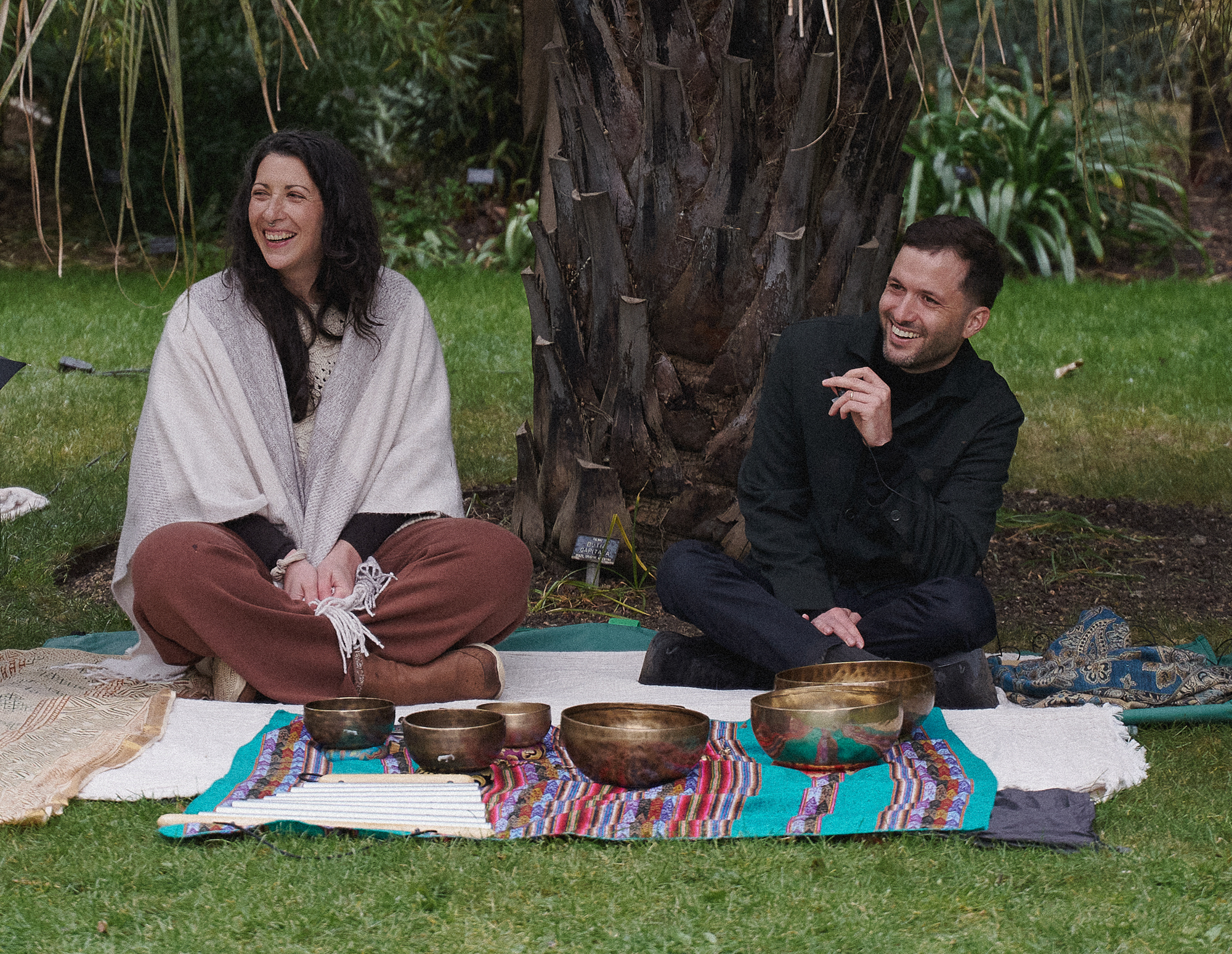 Diana Vela and Daniel the Gardener seated beside singing bowls during the guided programme.