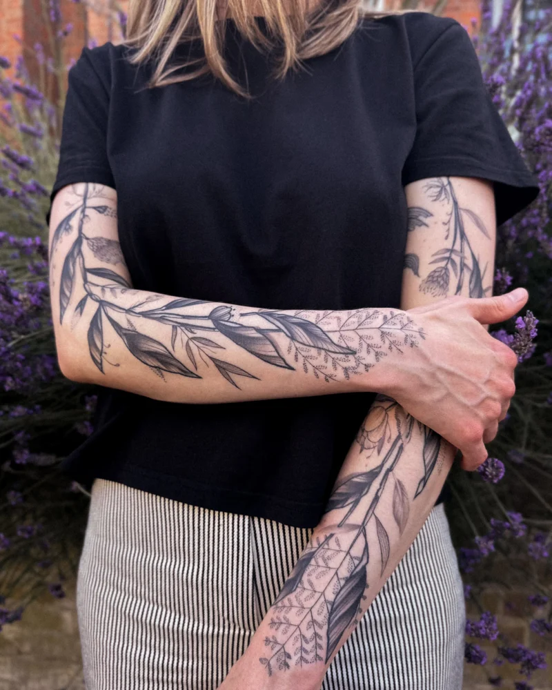 Freehand botanical tattoo across the arms