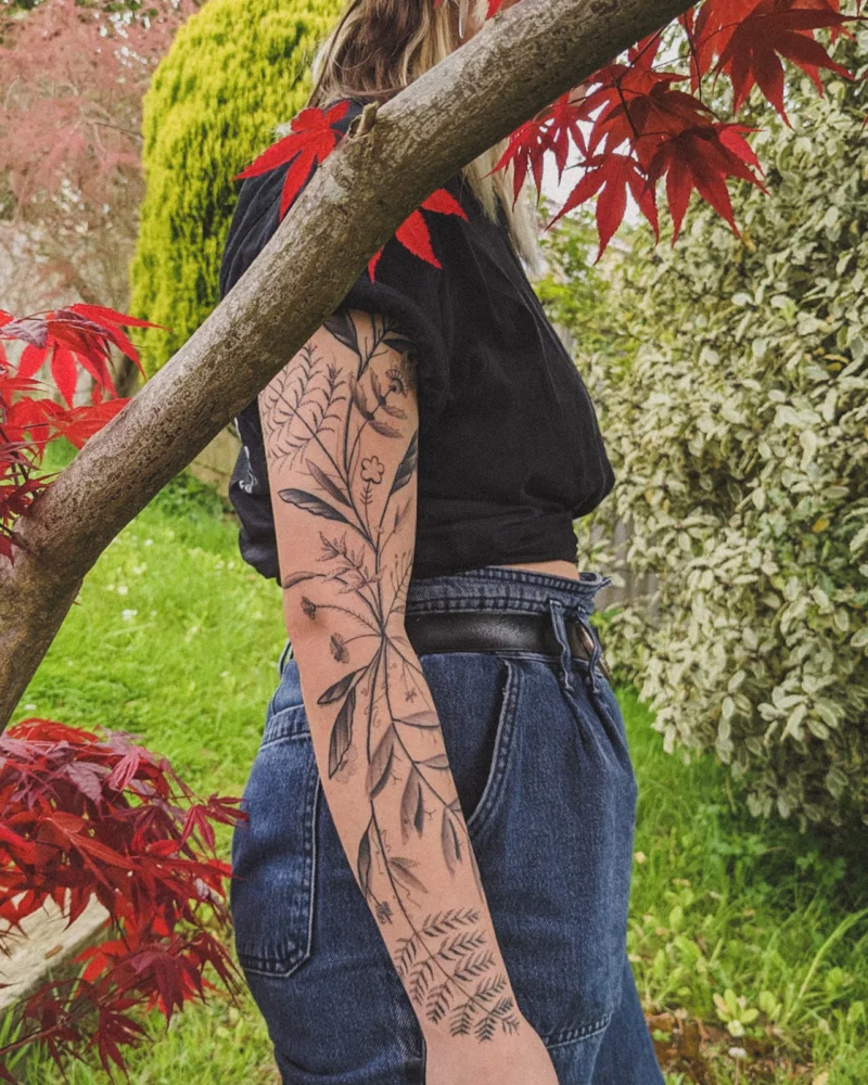 Another view of a freehand botanical tattoo across the arms