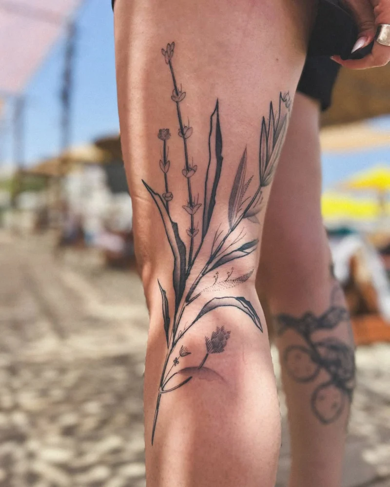 Freehand botanical tattoo across the legs