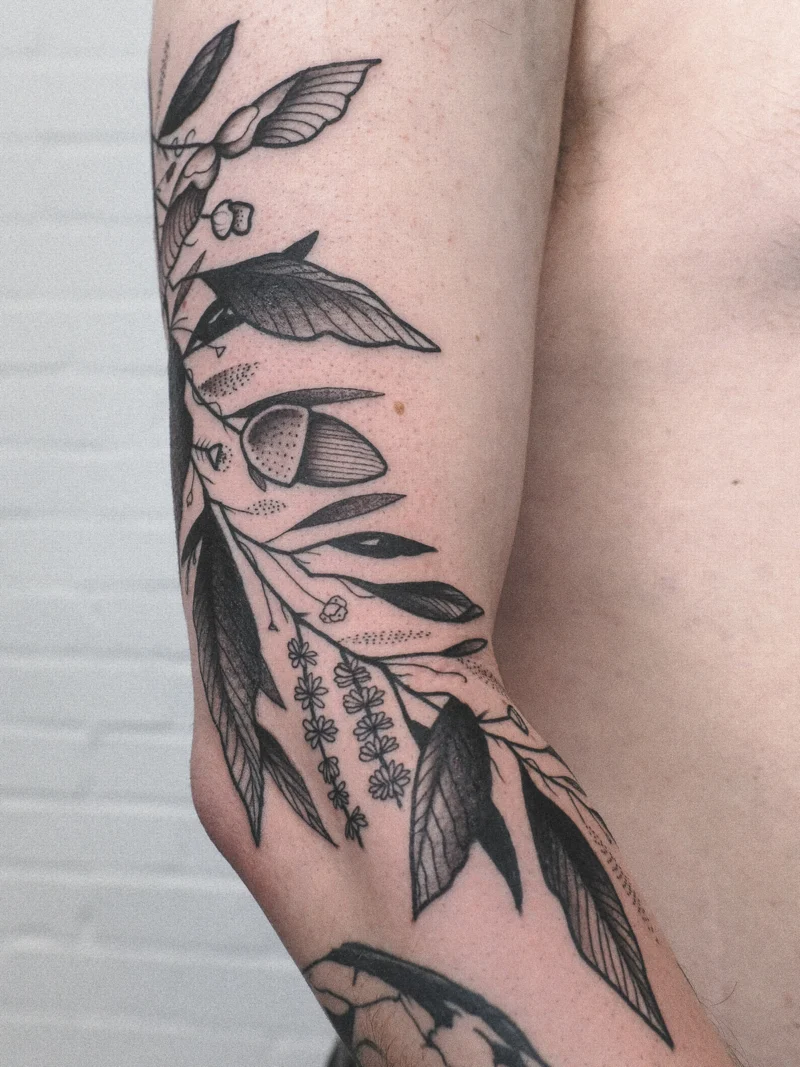 Freehand botanical tattoo across the arms