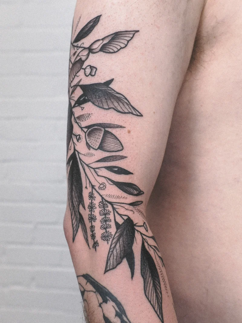 Another view of a freehand botanical tattoo across the arms
