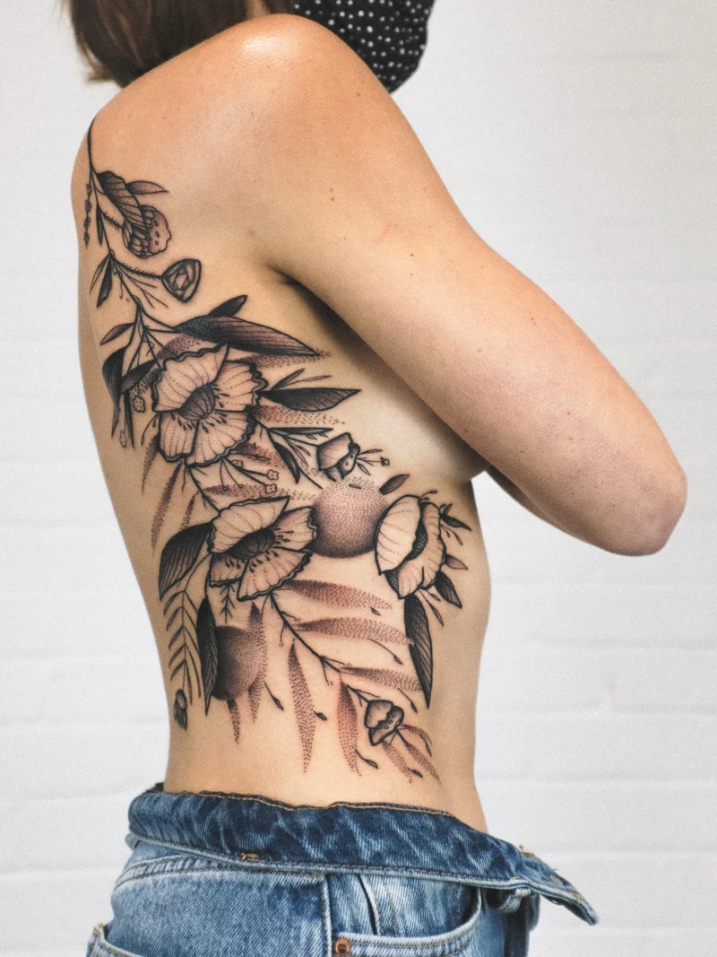 Freehand botanical tattoo across the ribs