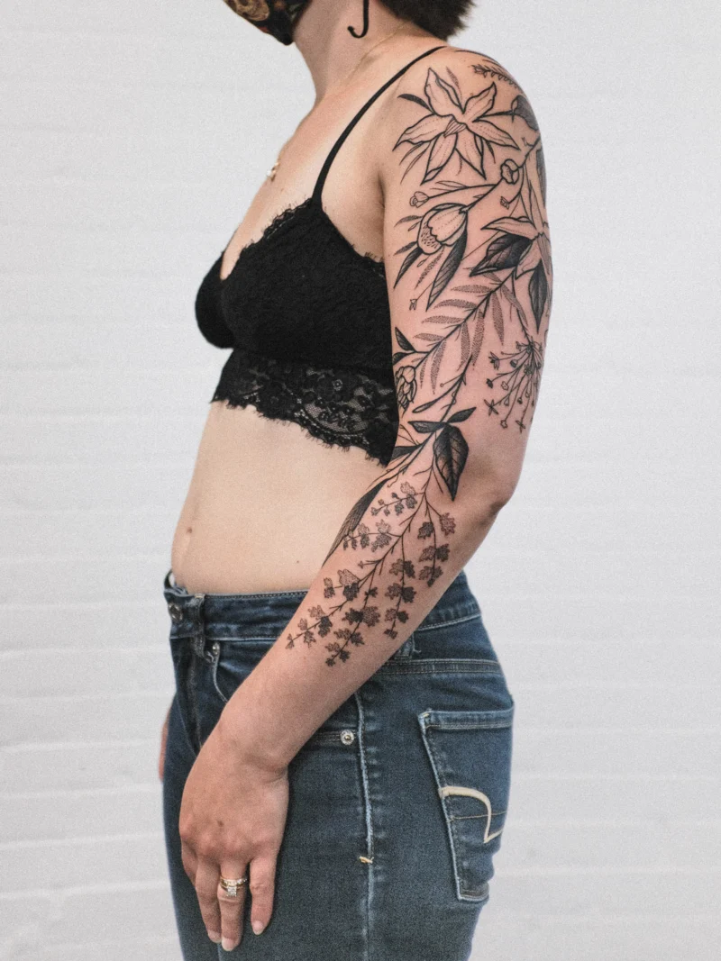 Freehand botanical tattoo across the arms