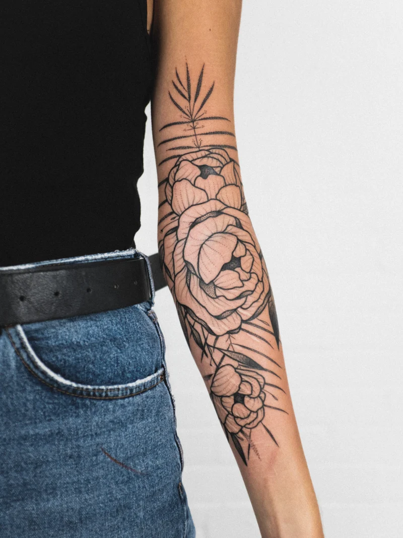 Freehand botanical tattoo across the arms