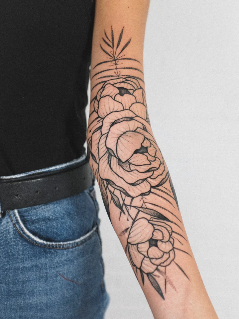 Another view of a freehand botanical tattoo across the arms