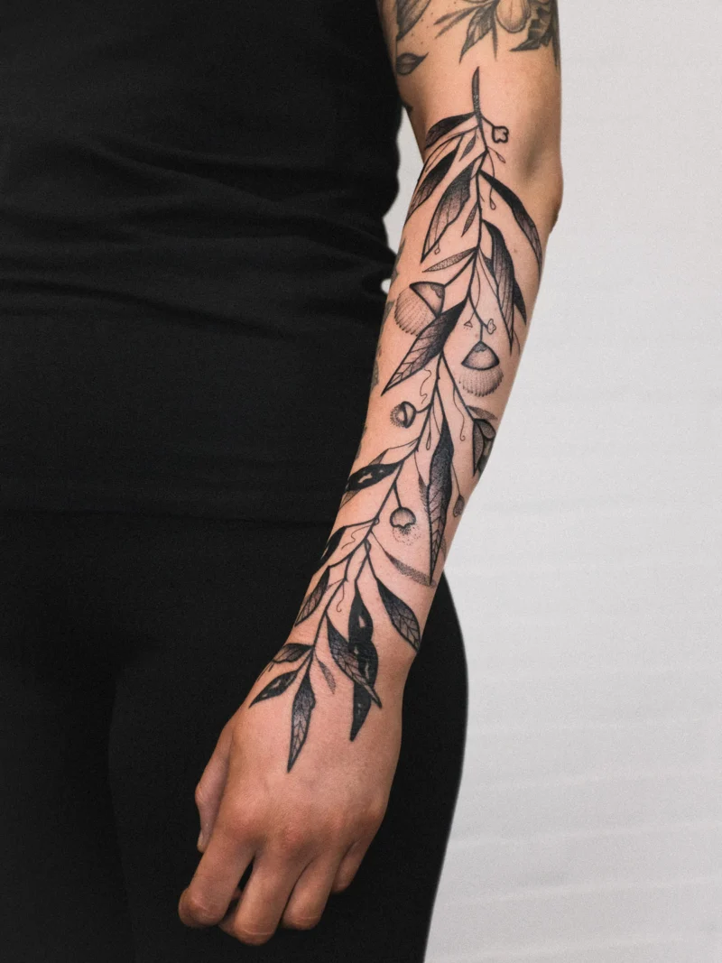 Freehand botanical tattoo across the arms