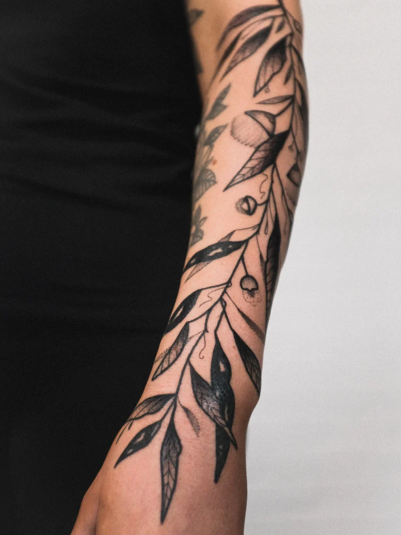 Another view of a freehand botanical tattoo across the arms