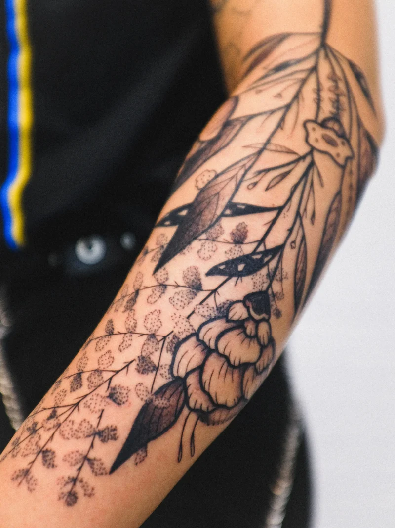 Freehand botanical tattoo across the arms