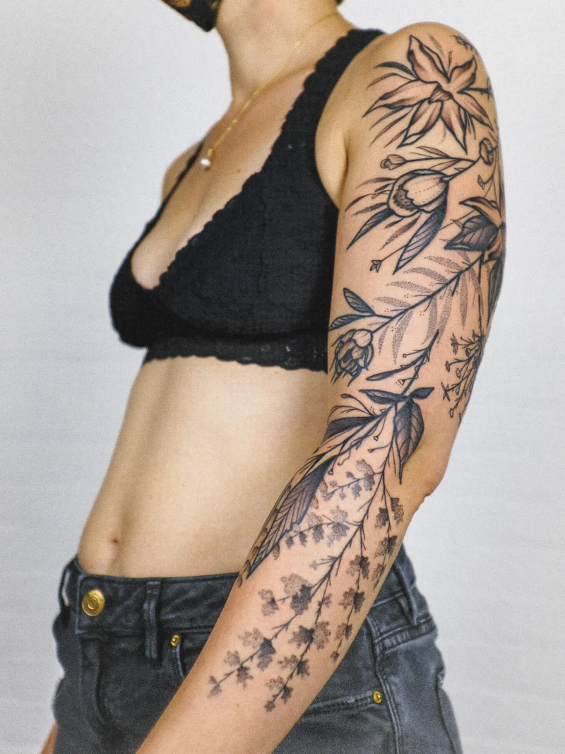 Freehand botanical tattoo across the arms