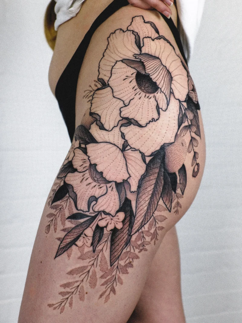Another view of a freehand botanical tattoo across the legs