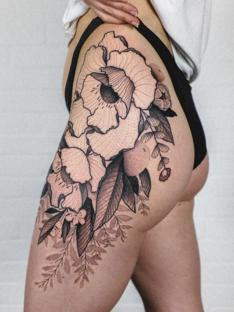 Freehand botanical tattoo across the legs