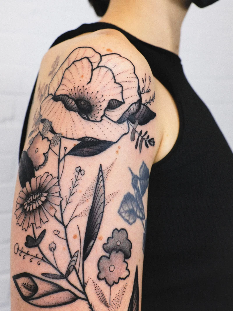 Freehand botanical tattoo across the arms