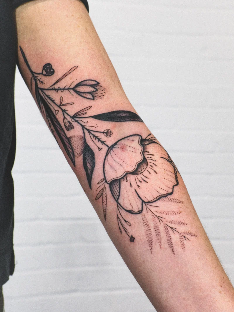 Freehand botanical tattoo across the arms