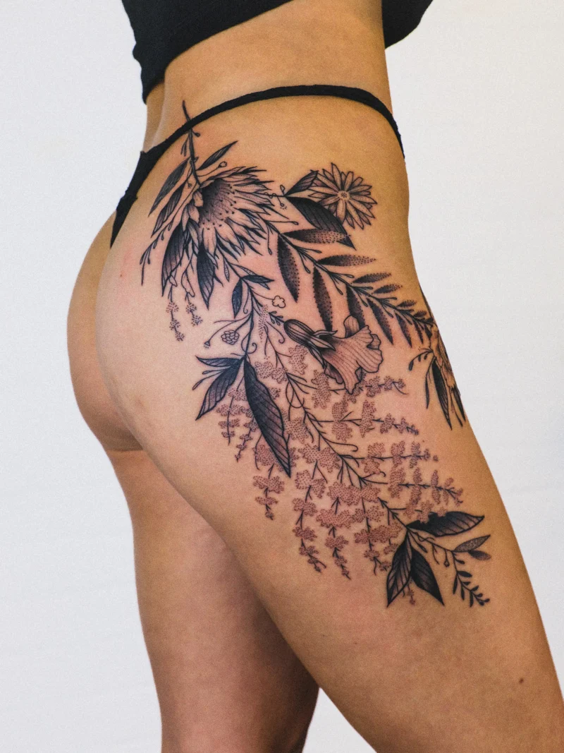 Freehand botanical tattoo across the legs