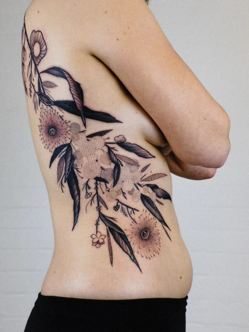 Freehand botanical tattoo across the ribs