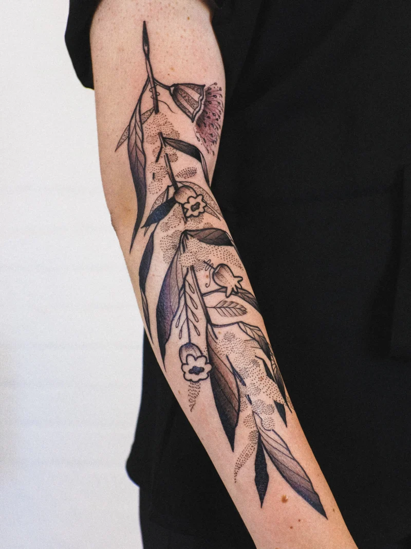 Freehand botanical tattoo across the arms
