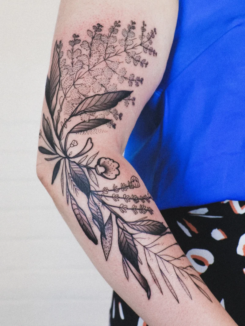 Freehand botanical tattoo across the arms
