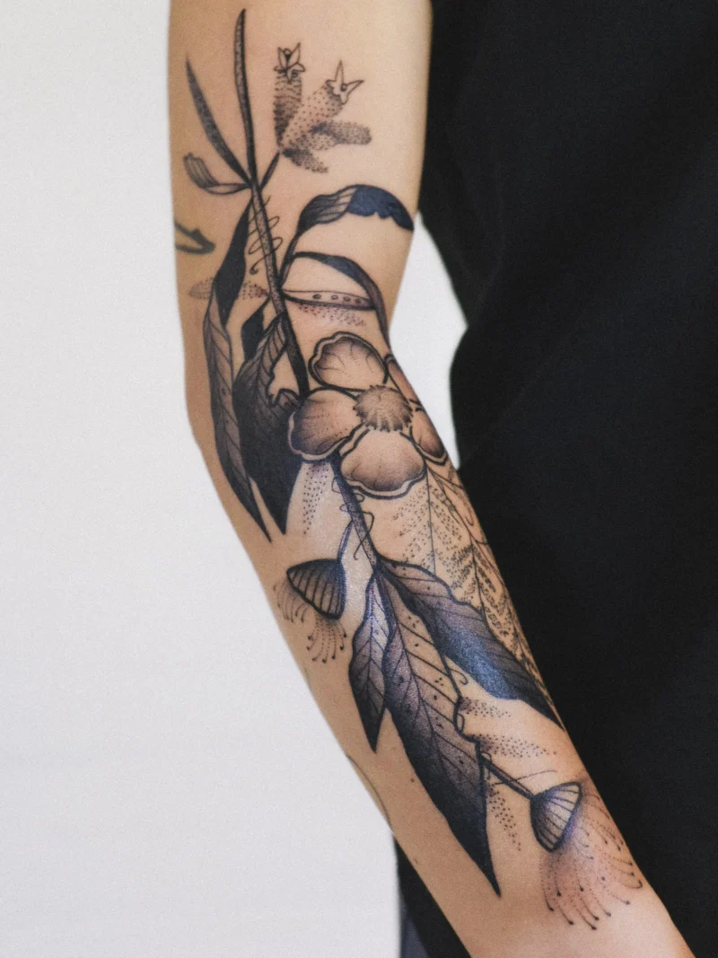 Freehand botanical tattoo across the arms