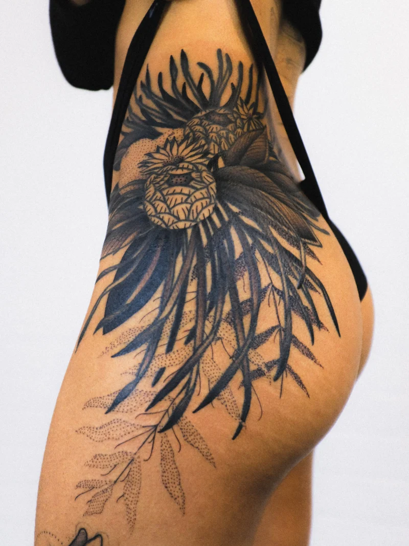 Freehand botanical tattoo across the legs