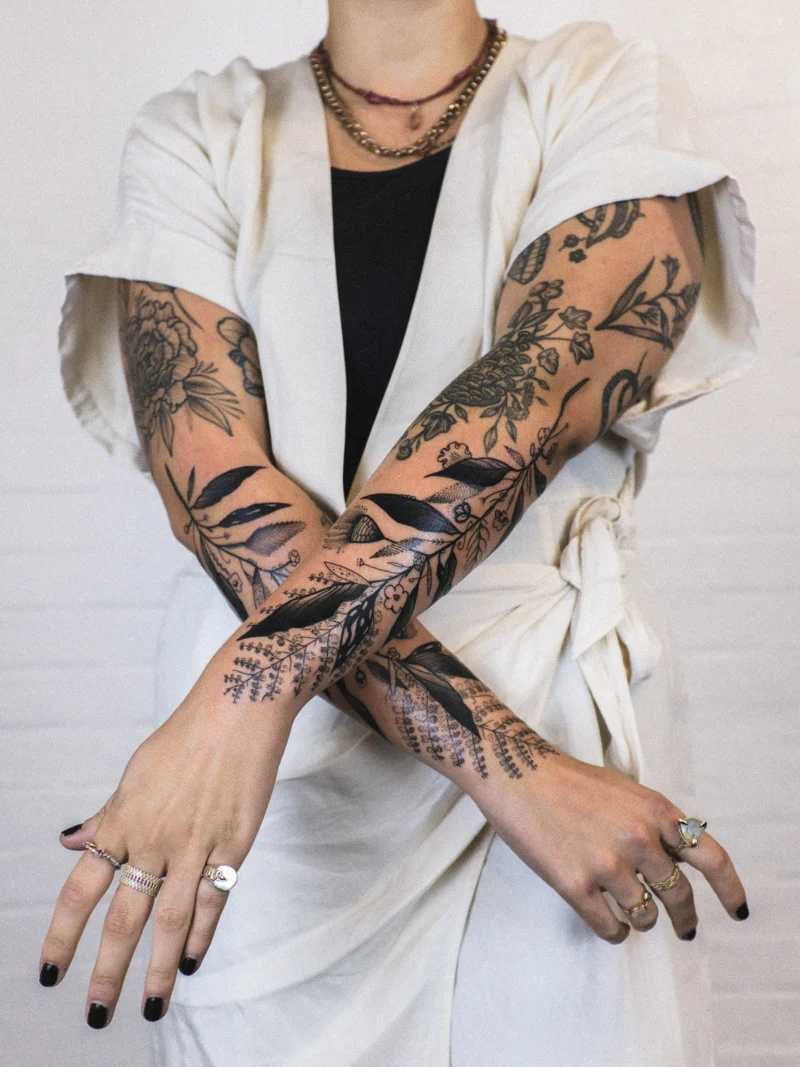 Freehand botanical tattoo across the arms