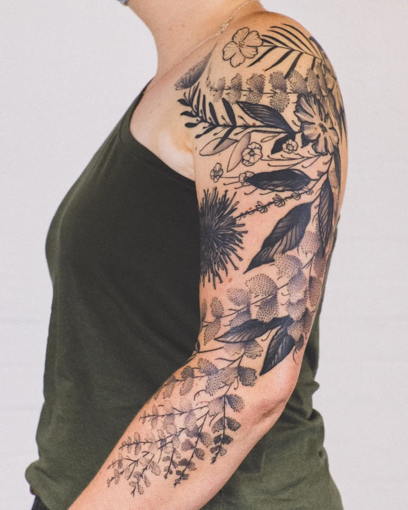 Freehand botanical tattoo across the arms