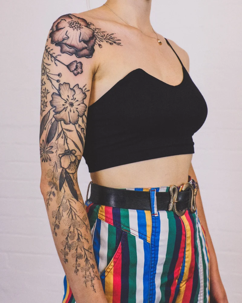 Freehand botanical tattoo across the arms