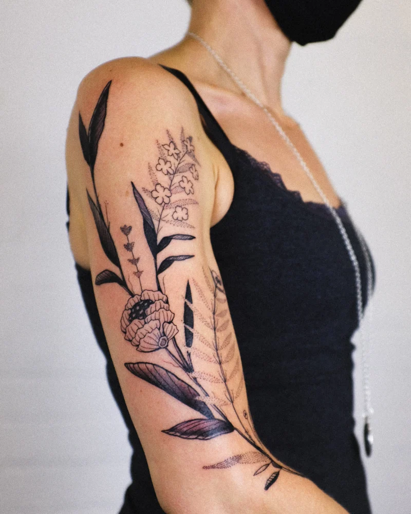 Freehand botanical tattoo across the arms