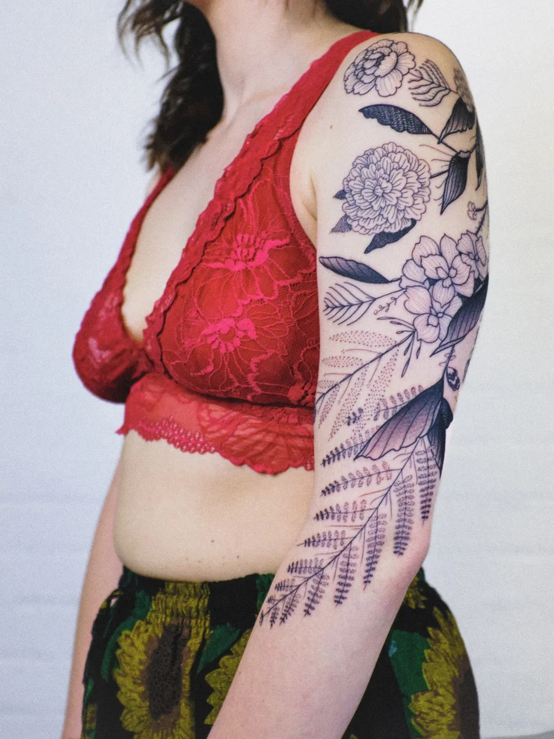 Freehand botanical tattoo across the arms