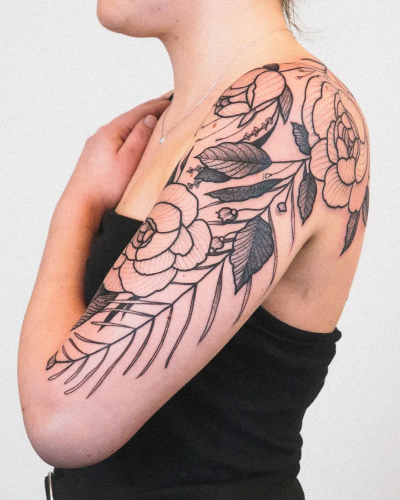 Freehand botanical tattoo across the arms
