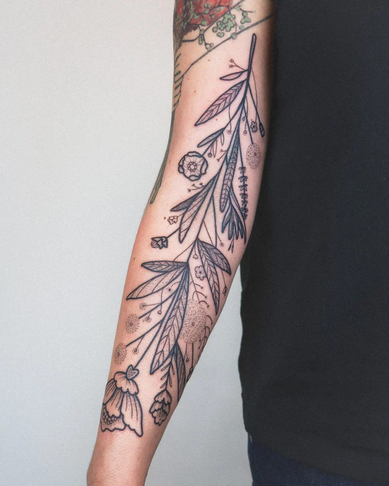 Freehand botanical tattoo across the arms