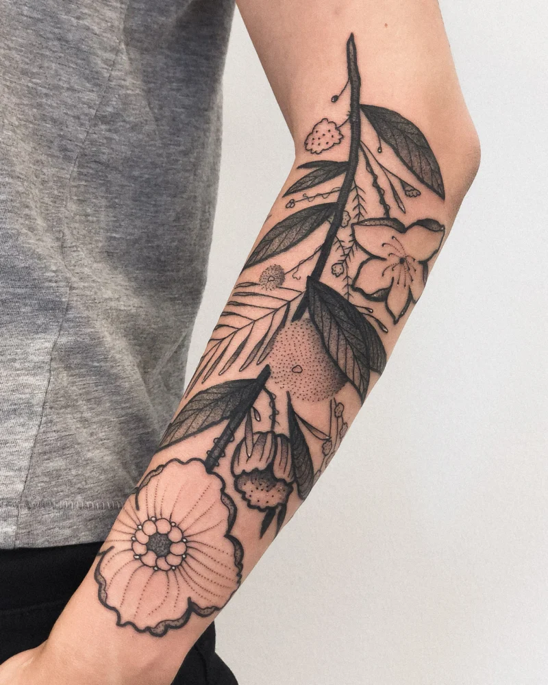 Freehand botanical tattoo across the arms