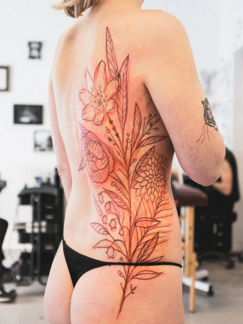 Another view of a freehand botanical tattoo across the back