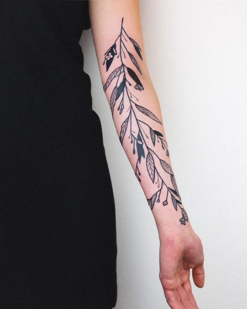 Freehand botanical tattoo across the arms