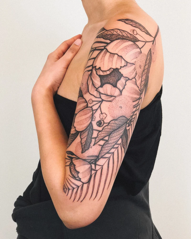 Freehand botanical tattoo across the arms
