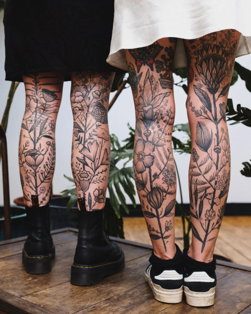 Freehand botanical tattoo across the legs