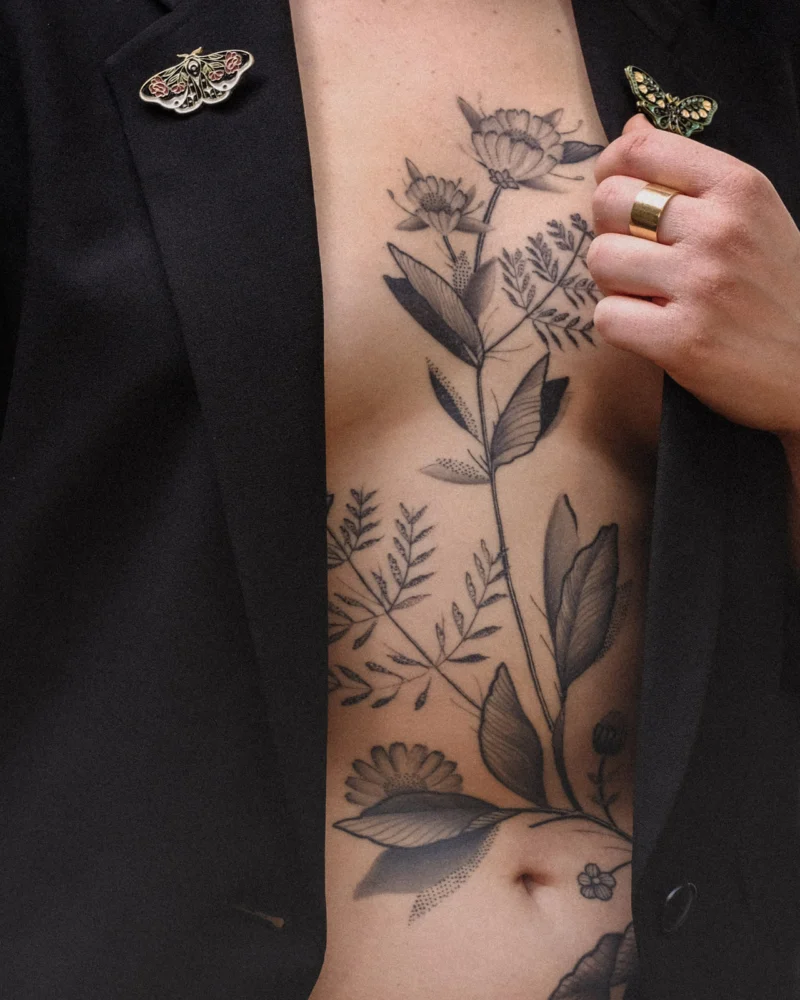 Another view of a freehand botanical tattoo across the front torso