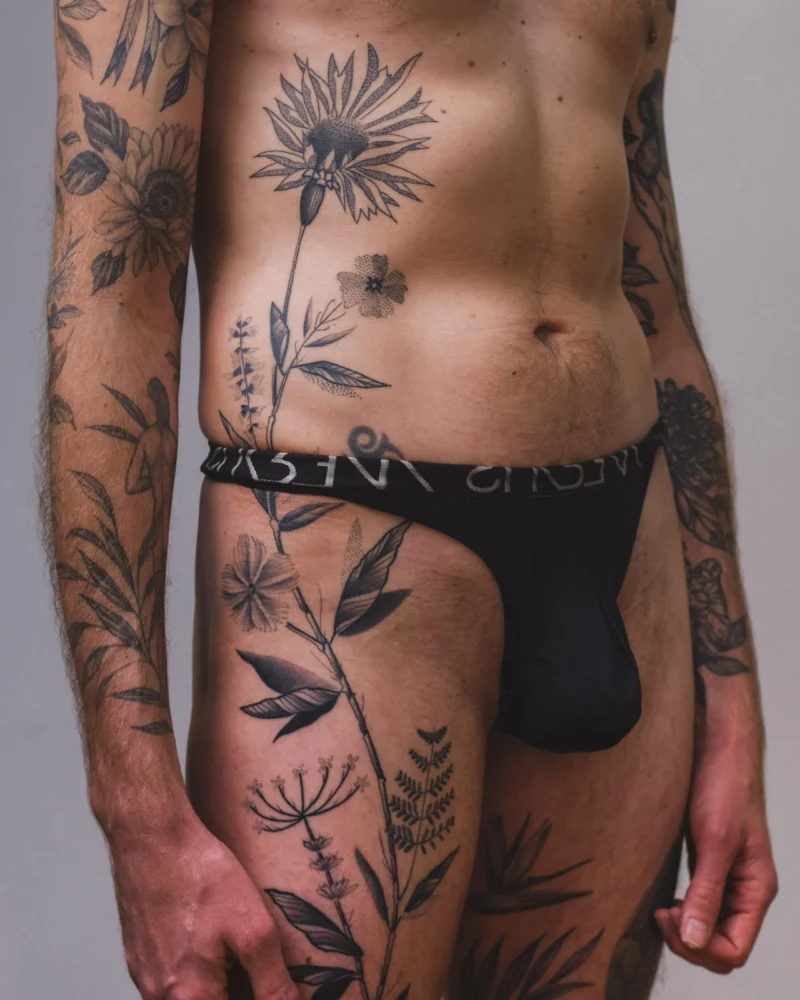 Another view of a freehand botanical tattoo across the front torso