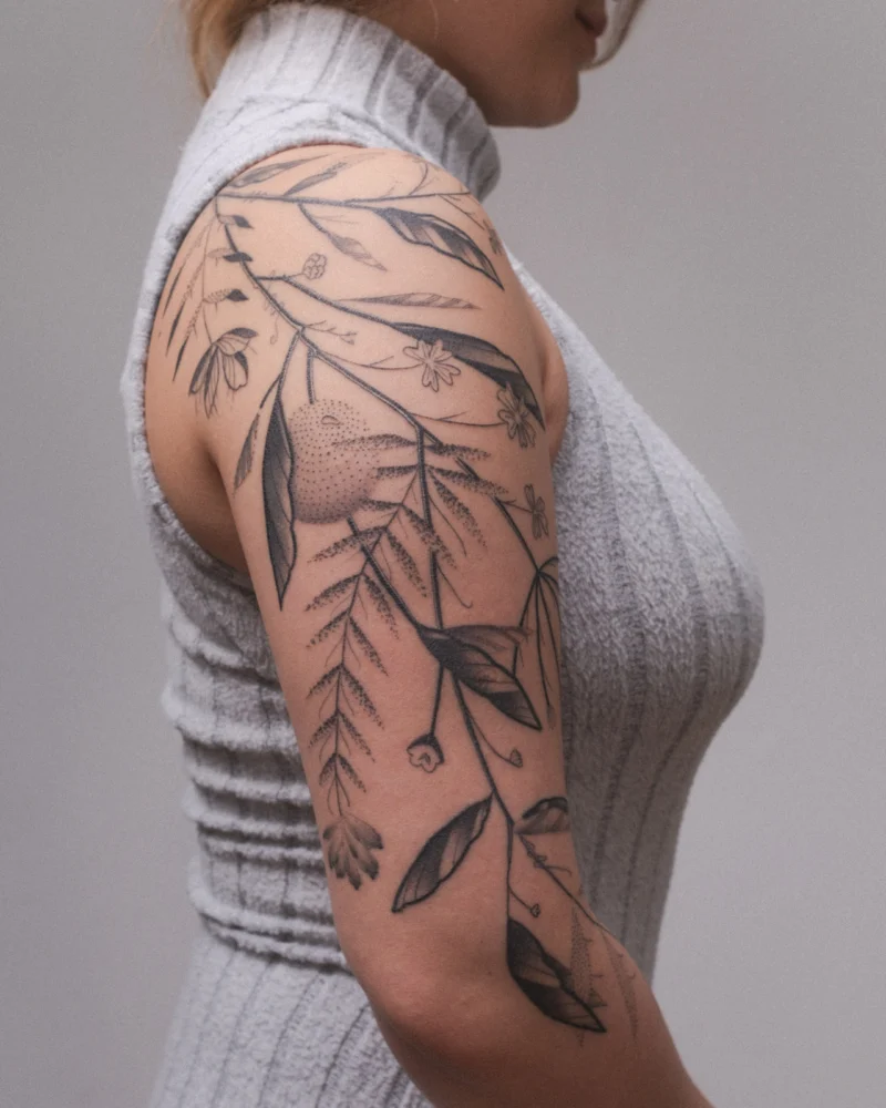 Another view of a freehand botanical tattoo across the arms