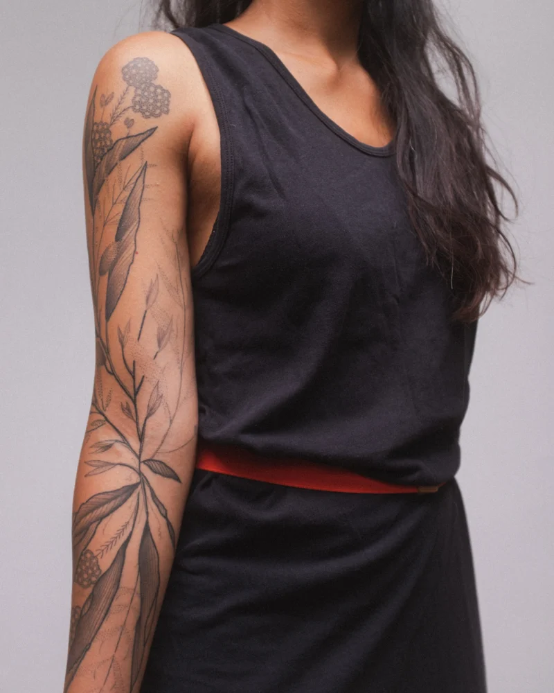 Freehand botanical tattoo across the arms