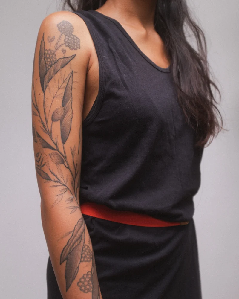 Another view of a freehand botanical tattoo across the arms