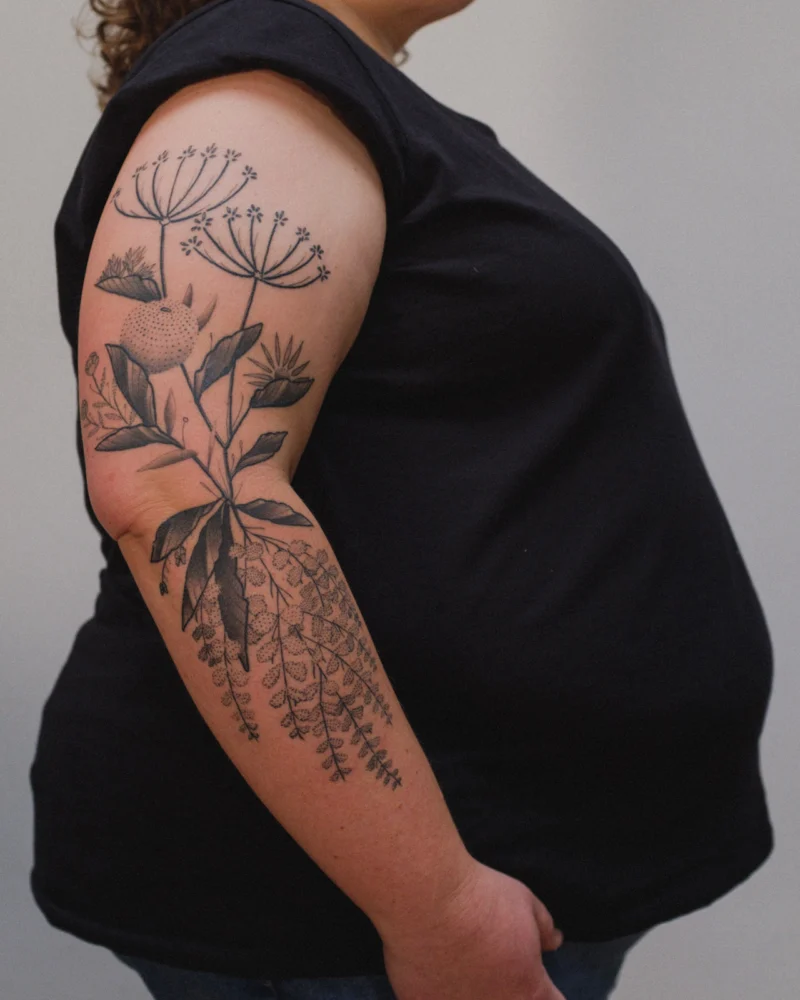 Freehand botanical tattoo across the arms