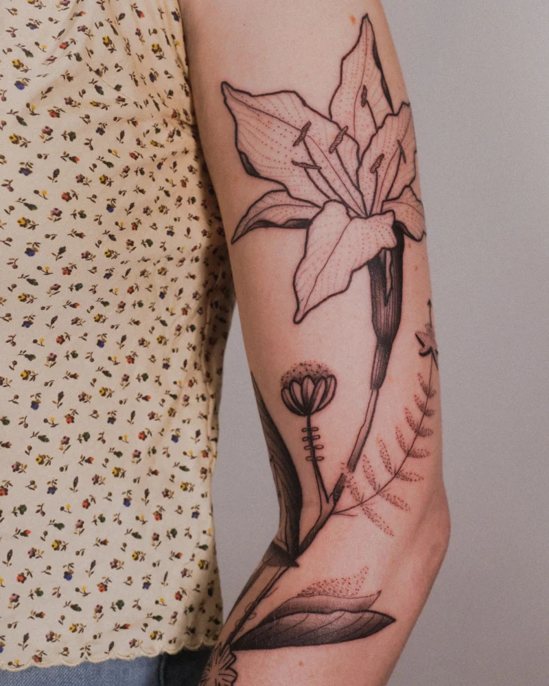 Another view of a freehand botanical tattoo across the arms