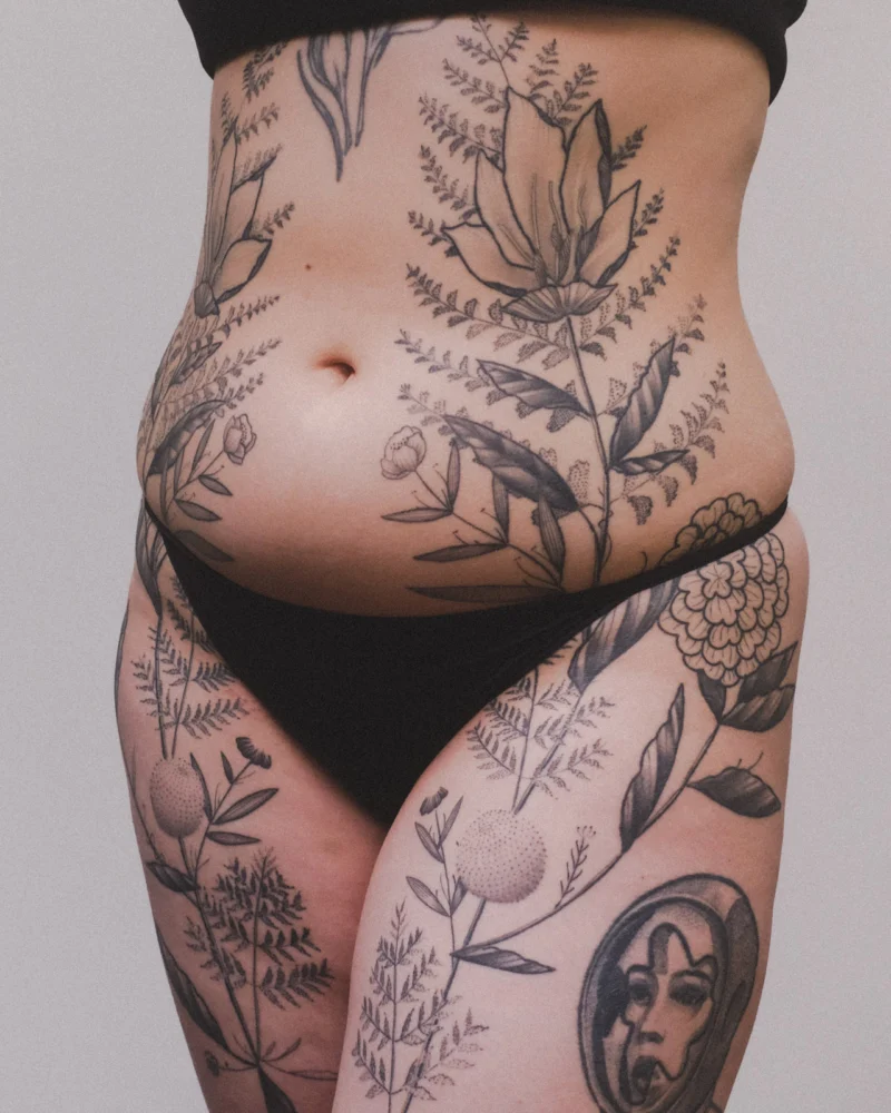 Another view of a freehand botanical tattoo across the front torso