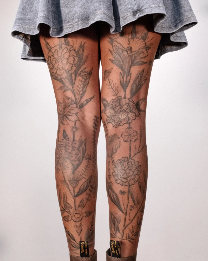 Freehand botanical tattoo across the legs