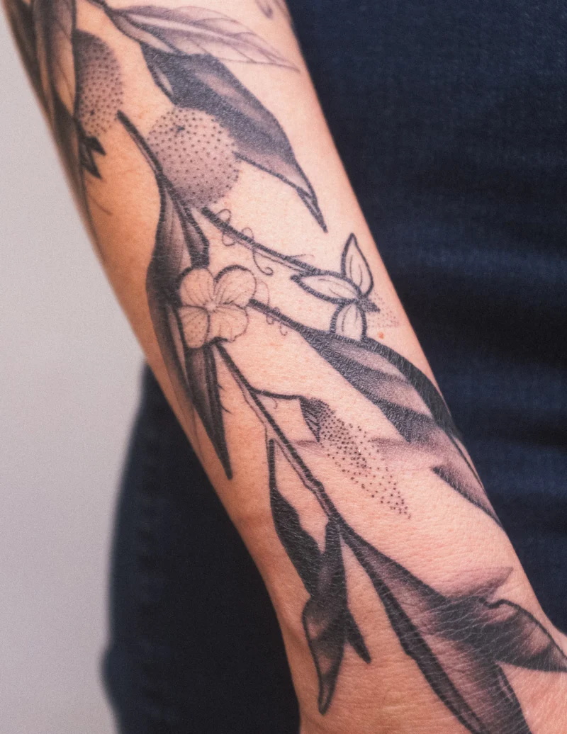 Another view of a freehand botanical tattoo across the arms