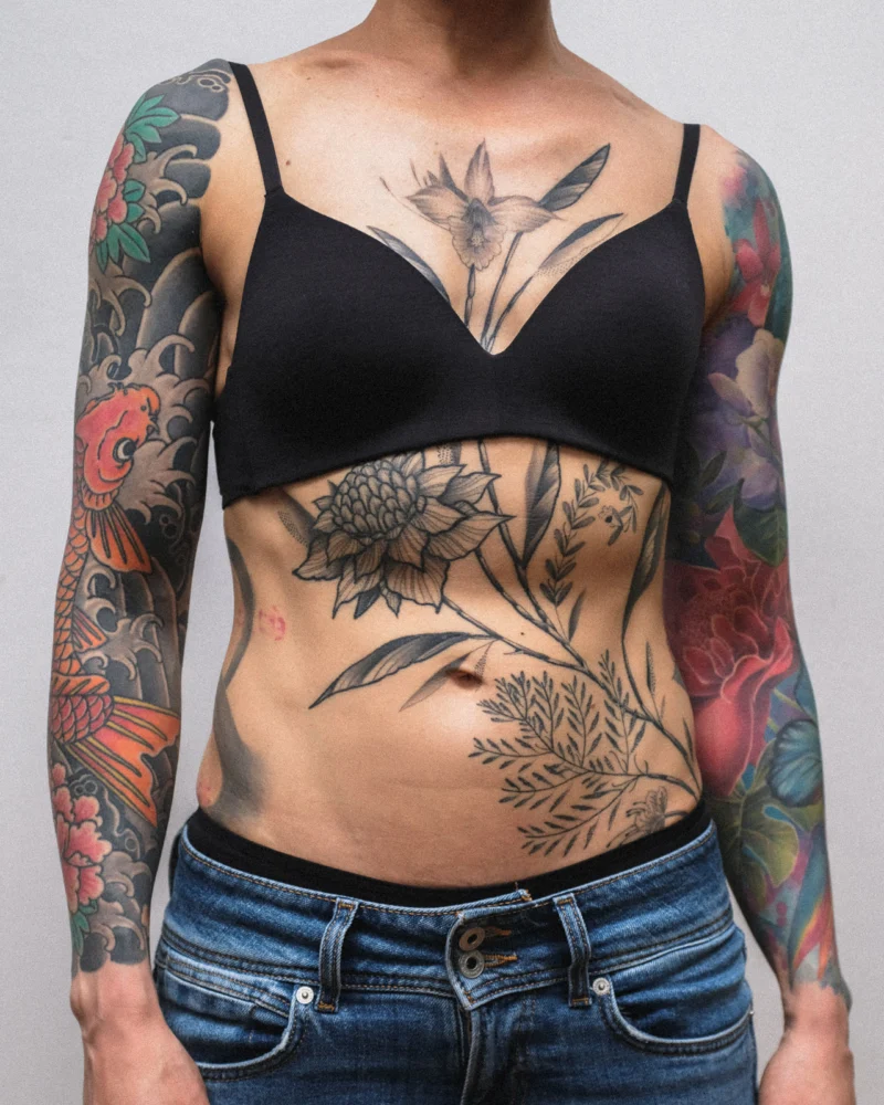 Freehand botanical tattoo across the front torso