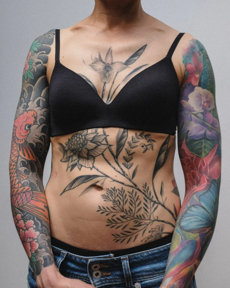 Another view of a freehand botanical tattoo across the front torso