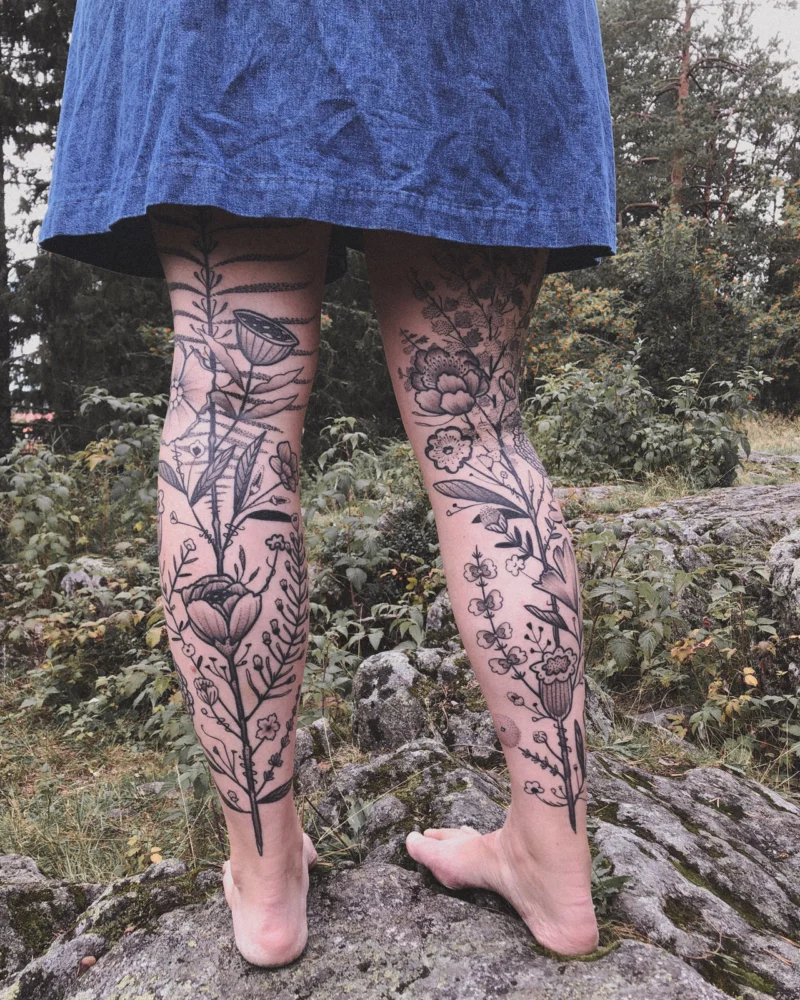 Freehand botanical tattoo across the legs