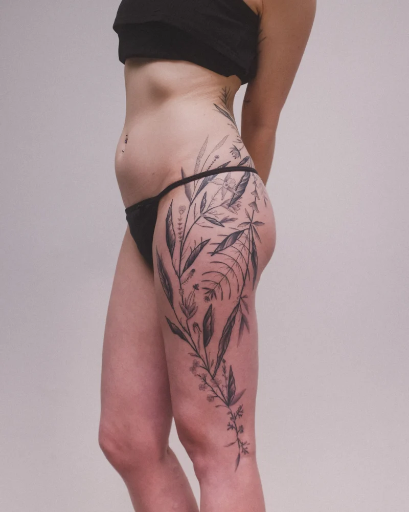 Freehand botanical tattoo across the legs